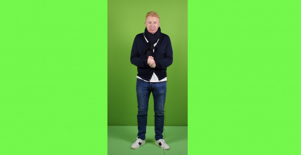 A person standing in front of a green screen