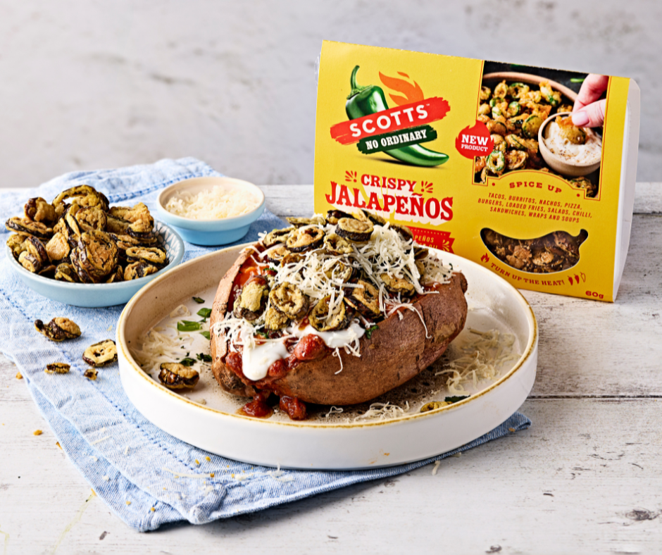 A baked potato with cheese and crispy jalapenos on a plate