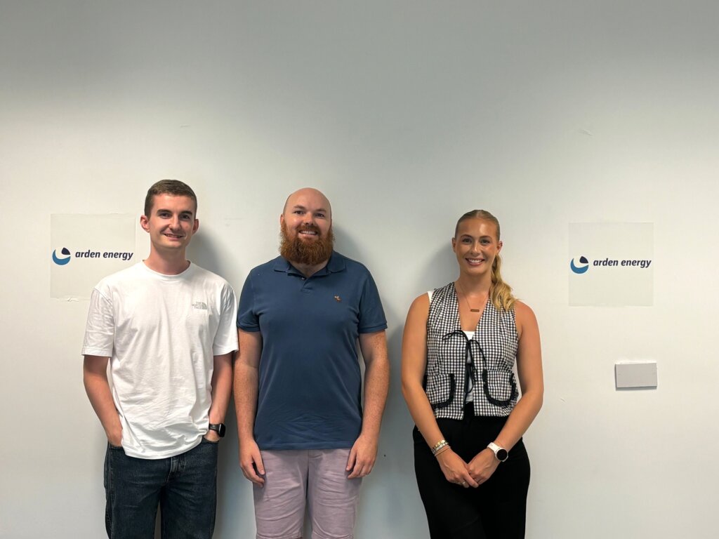 A group of people standing in front of a white wall.